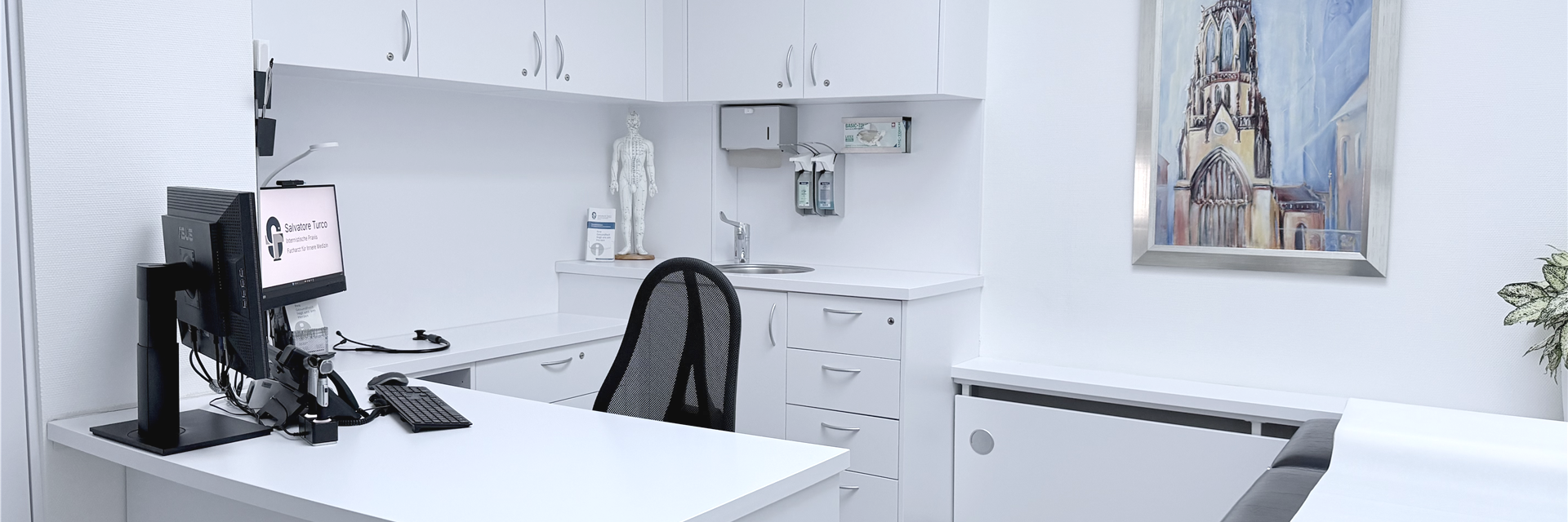 Modernes, helles Behandlungszimmer mit weißen Schränken und einem großen Schreibtisch